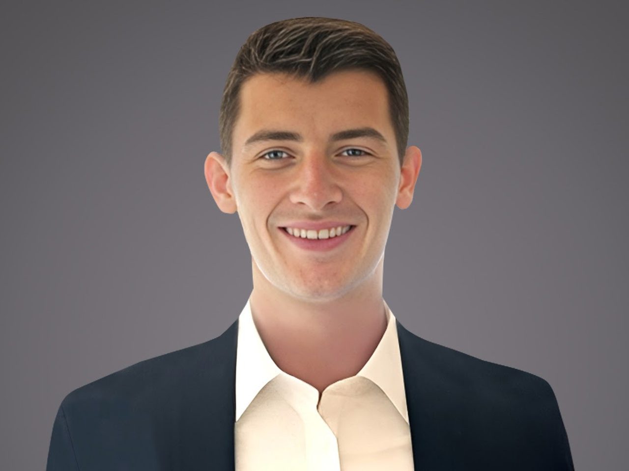 Smiling person with short dark hair wearing a dark blazer and white shirt, facing the camera against a neutral gray gradient background.