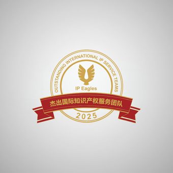 Smiling person with shoulder-length dark hair, wearing a white textured top and dangling earrings, against a neutral grey background.