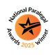 Badge rond orange avec une étoile noire et une ligne incurvée traversant l’étoile, et une petite pampille en bas, encadré par un cadre noir octogonal.