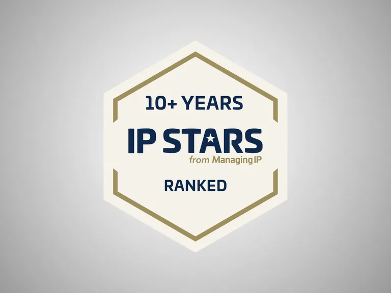 Hexagon badge with text celebrating over 10 years of IP Stars from Managing IP, ranked, on a light grey background.