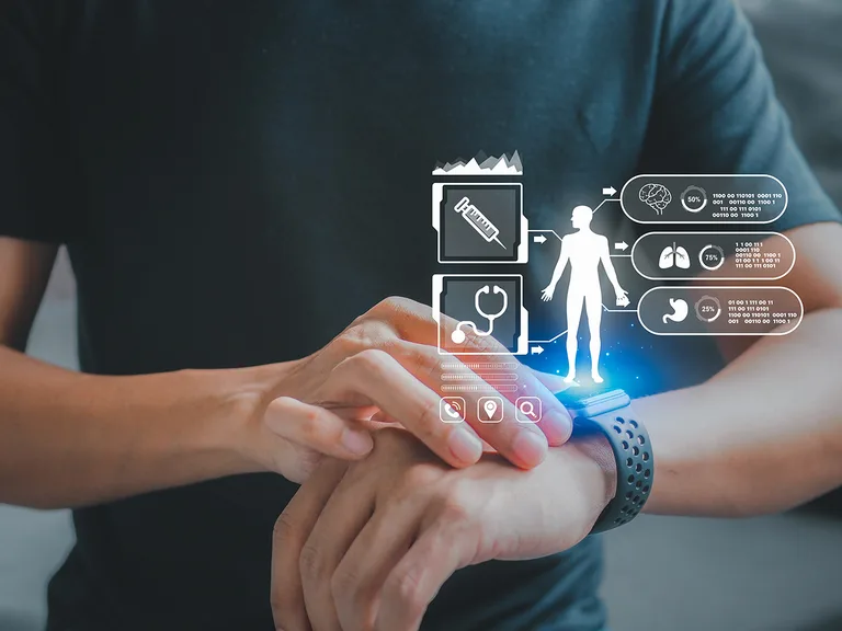 Person wearing a smartwatch with holographic medical icons—syringe, stethoscope, brain, lungs and stomach—surrounding a human figure and data panels.