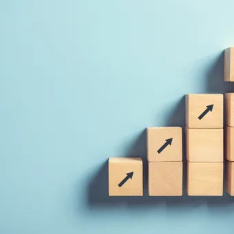 Hand arranging wooden blocks with upward arrows on a light blue background, illustrating growth or progress.