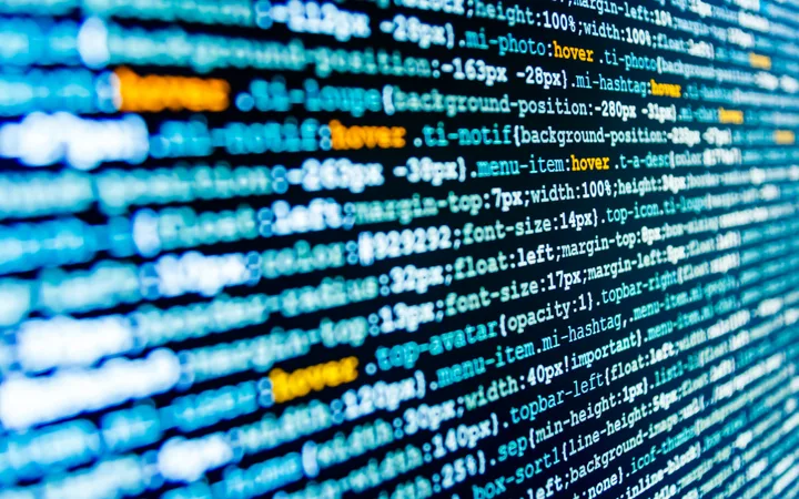 Close-up of colourful computer code on a screen, with syntax highlighting in shades of blue, orange, and yellow.