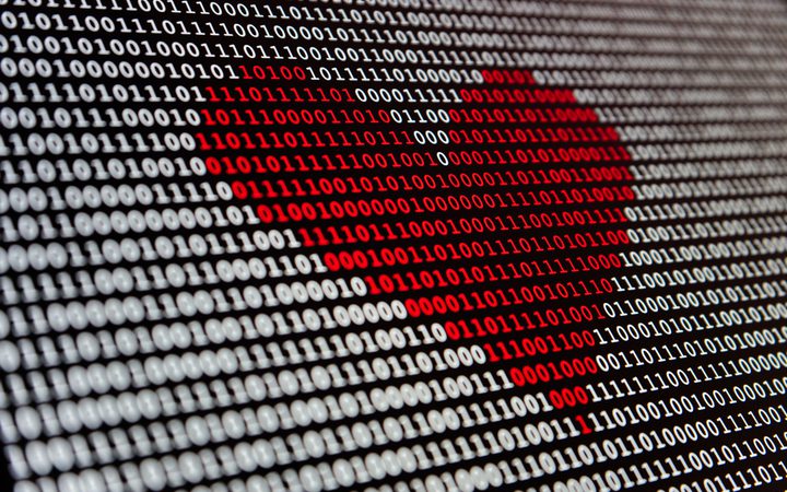 Binary code with red-highlighted pattern forming a heart shape.