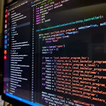 A computer screen displaying colorful Python programming code with a dark background, focused on defining a class and handling different course types.
