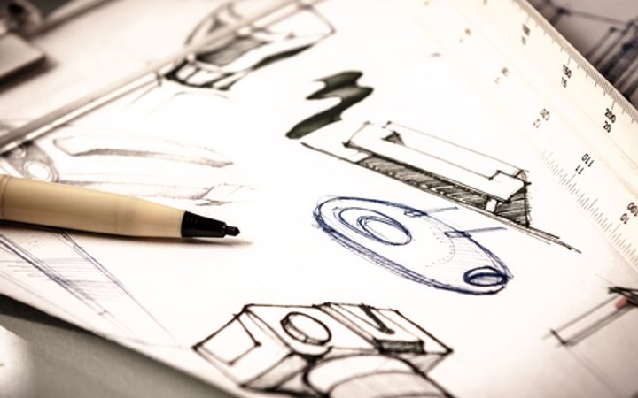 Sketches of furniture and a pen on paper, with a ruler in the background. Focus on the creative design process and planning for interior elements.