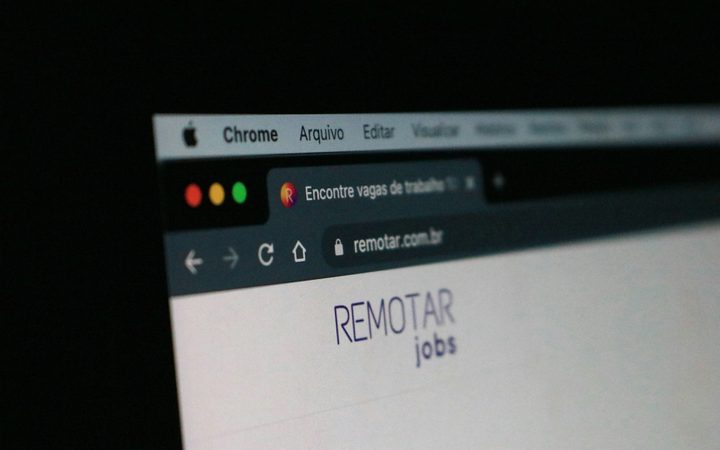 Close-up of a computer screen displaying a website with the text "REMOTE jobs" and browser tabs, against a dark background.