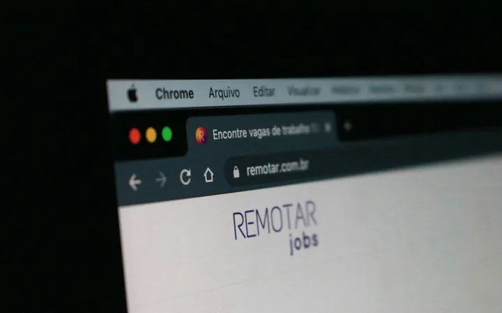Close-up of a computer screen displaying a website with the text "REMOTE jobs" and browser tabs, against a dark background.