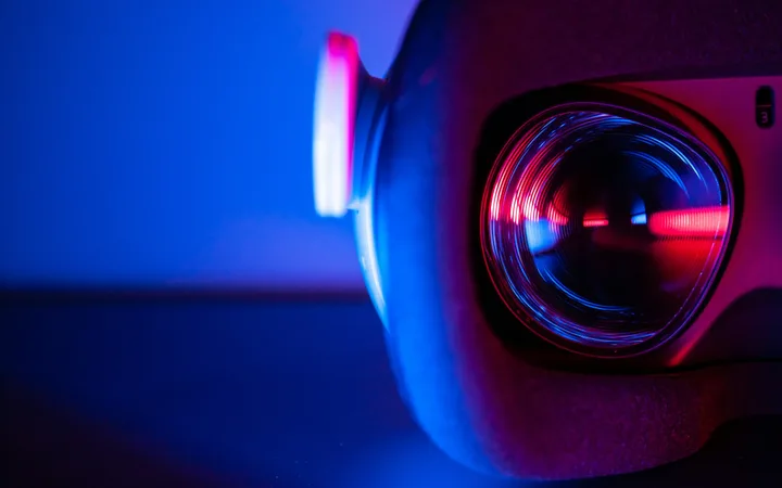 Close-up of a camera lens with vibrant red and blue neon lights, creating a futuristic and dynamic visual effect.