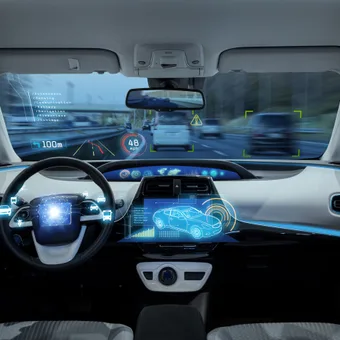 Inside a futuristic autonomous car with digital displays, sensors, and a heads-up display guiding the vehicle on a busy highway.
