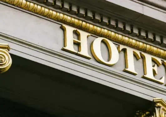 Close-up of a building façade with a gold-lettered sign reading "HOTEL" and ornate gold decorative elements.