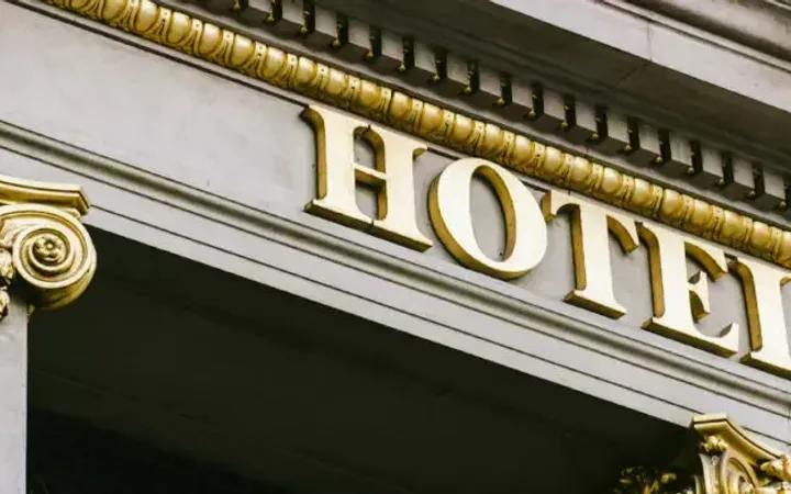 Close-up of a building façade with a gold-lettered sign reading "HOTEL" and ornate gold decorative elements.