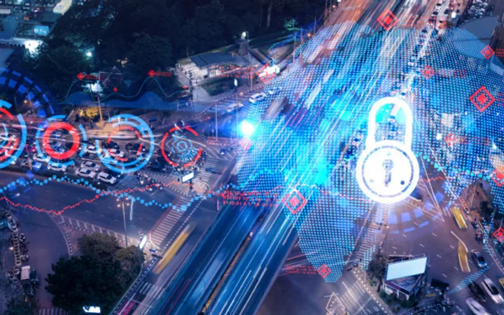 A city street at night overlaid with digital security icons, graphs, and data streams highlighting cybersecurity and digital protection themes.