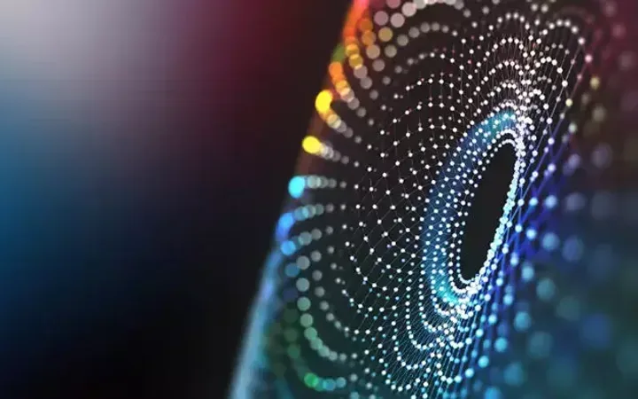 A digital abstract image with concentric circles of colorful dots forming a spiral pattern on a dark background.