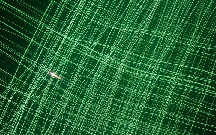 Green digital grid with intersecting glowing white lines and a pink light flare, creating an abstract futuristic pattern.