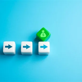 Five white dice with blue arrows pointing right, leading to a green die with a money bag and dollar sign, on a light blue background.
