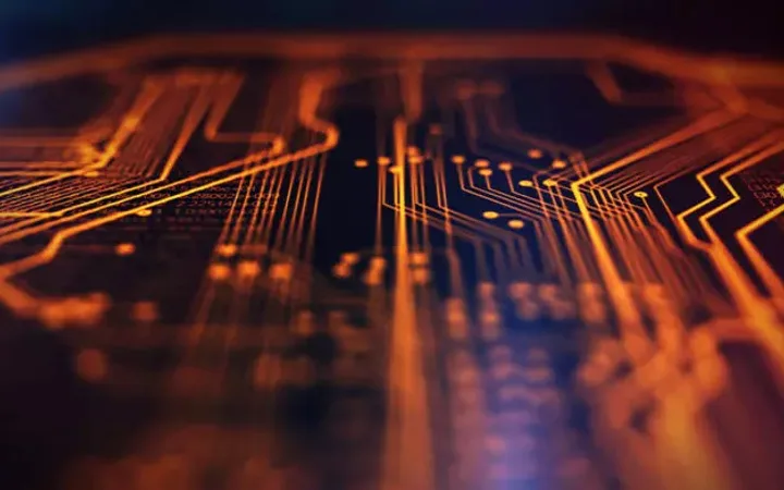 Close-up of orange electronic circuit lines on a dark background, resembling a futuristic digital motherboard or chipset.