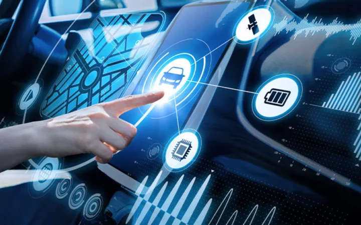 A person interacts with a futuristic touchscreen display inside a vehicle, showing icons for navigation, car control, battery, and communication.