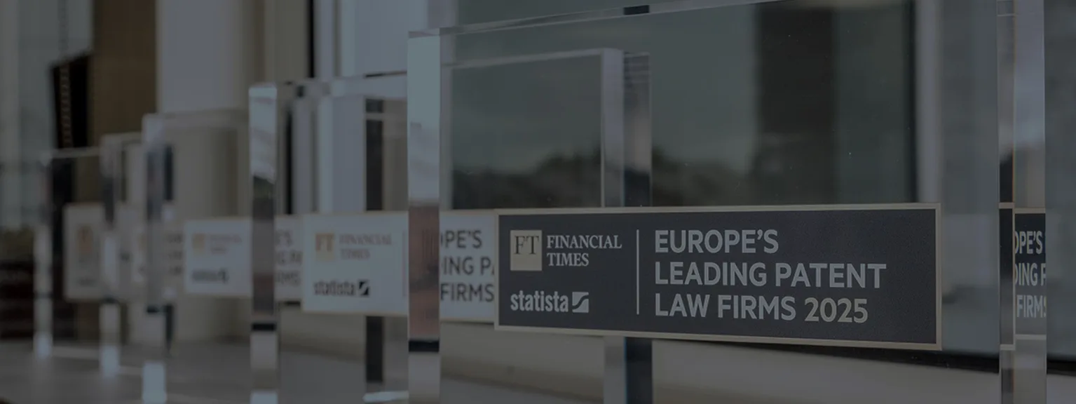 Row of clear glass award plaques on a windowsill, titled Europe's Leading Patent Law Firms 2025 with FT and Statista logos.