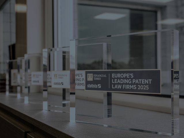 Row of clear glass award plaques on a windowsill, titled Europe's Leading Patent Law Firms 2025 with FT and Statista logos.