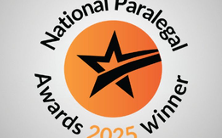 Orange circular badge featuring a black star with a swoosh, surrounded by curved text reading 'National Paral... Awards 2025 winner' on a light grey background.