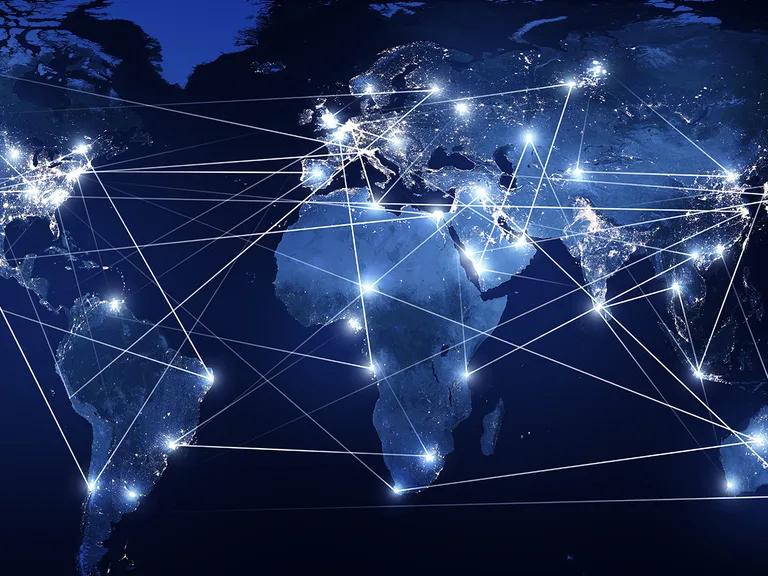 Blue night-world map with bright city lights and glowing white lines linking cities across continents.