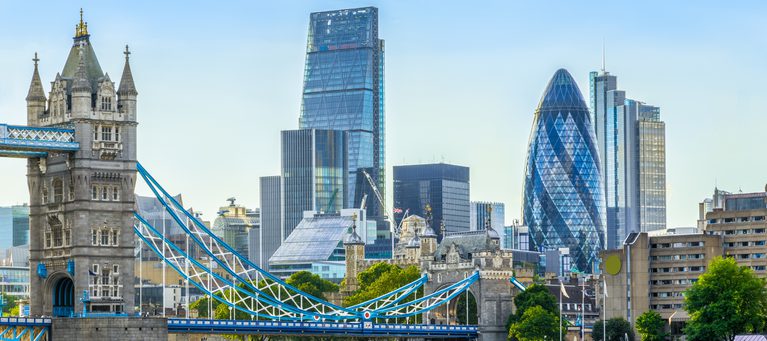London skyline with the Tower Bridge in the foreground and modern skyscrapers behind on a clear day.