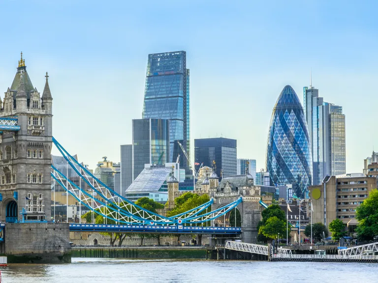 London skyline with the Tower Bridge in the foreground and modern skyscrapers behind on a clear day.