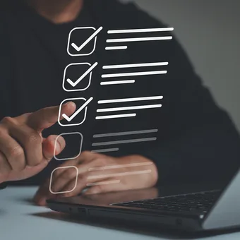 A person interacts with a digital checklist overlaid on a laptop, with three checked boxes and additional unmarked options.
