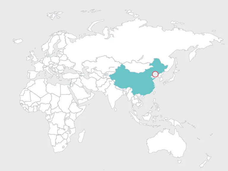 Weltkarte mit China in Türkis hervorgehoben; roter Ring markiert eine Stadt an der Ostküste Chinas.
