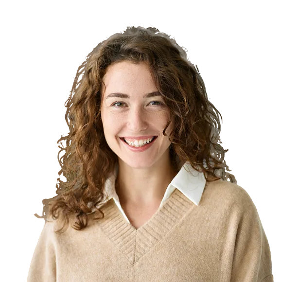 Smiling person with curly brown hair wearing a beige sweater over a white collared shirt.