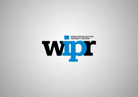 Logo di World Intellectual Property Review (WIPR): grandi lettere nere con “IP” blu al centro, piccolo testo in alto, sfondo grigio sfumato.