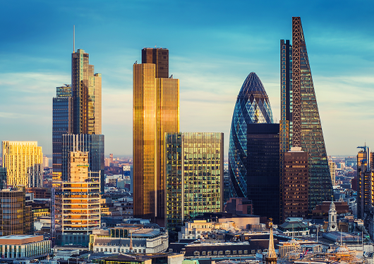 London skyline at golden hour with glass skyscrapers, including the Gherkin, under a clear blue sky.